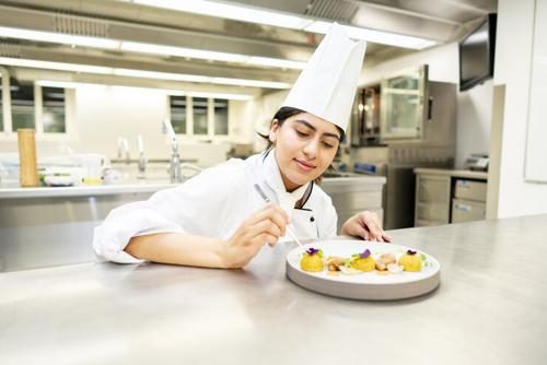 BHMS culinary certificate student in a professional kitchen