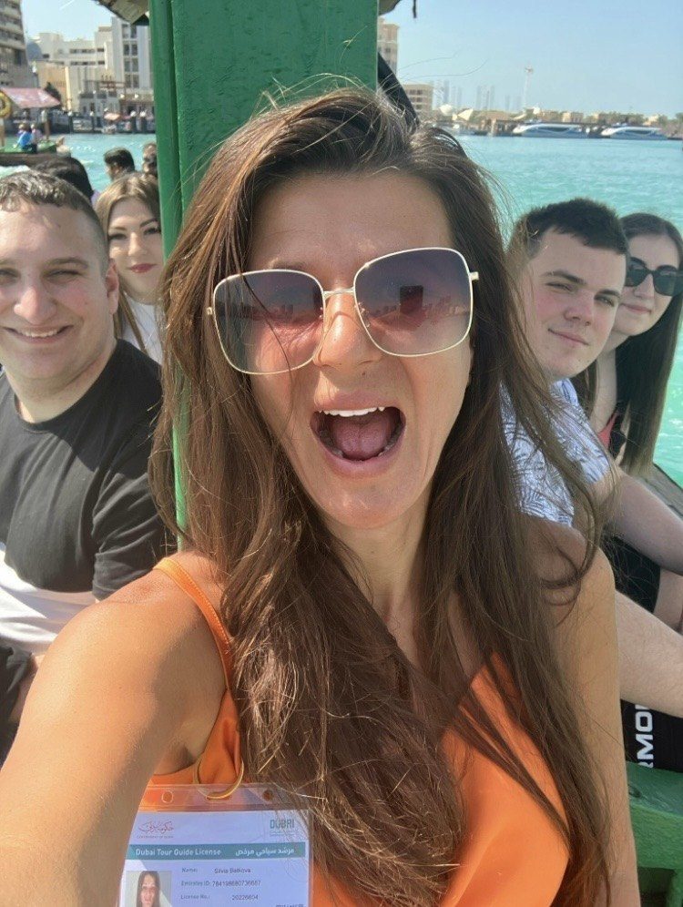 Silvia laughing with guests on a wooden abra boat